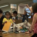 Photo by Brandon Taylor/Whidbey News-Times                                John Del Pretes fourth-grade class tears into the box that has their published book Invisible Pollution in the Salish Sea.