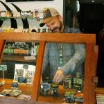 Photo by Kira Erickson/Whidbey News-Times                                Budtender Tyler Small arranges a display behind a window in Island Herb. The Freeland cannabis store experienced record-breaking sales in March.