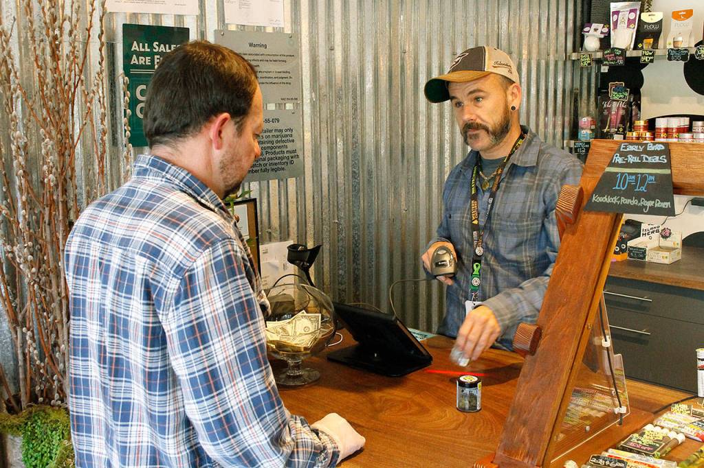 Photo by Kira Erickson/Whidbey News-Times                                Budtender Tyler Small helps a customer with a purchase at Island Herb.