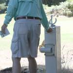 Players at the Island Greens golf course pay by the honor system. Here a customer places his payment in a drop box Monday. (Photo by Jim Waller/Whidbey News-Times)