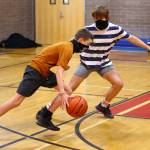 Coupevilles Cole White dribbles against the defense of Logan Downes at a boys basketball workout this week. (Photo by John Fisken)