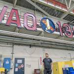 Photo provided
Langley business owner Tim Leonard stands below the growler squadrons completed sign, which includes a sword made of neon. He helped Lt. Cmdr. Ryan Salcido of VAQ-136 to build the sign.