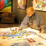 Artist Louie Rochon demonstrates the process of how he paints at his Clinton studio on Thursday. Photo by Kira Erickson/Whidbey News-Times