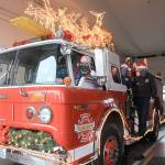 Santa and his elves, Jen Porter and Dalton Martin, have begun decorating Central Whidbey Fire and Rescues Santa Mobile, which begins making the rounds on Dec. 7. Photo by Emily Gilbert/Whidbey News-Times
