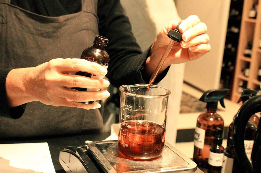 Karen Wilson adds to the palo santo blend of oils. Photo by Kira Erickson/Whidbey News-Times