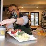 Jim Goodall arranges some food in the to-go window, where customers pick up their food from outside at Langley Kitchen. Photo by Kira Erickson/Whidbey News-Times