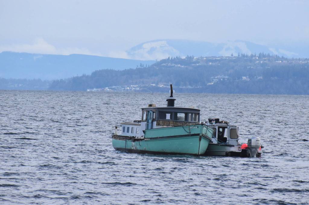 A salvage company towed the boat to La Conner Thursday morning. It had been floating around Coupeville for the past few years. Photo by Emily Gilbert/Whidbey News-Times