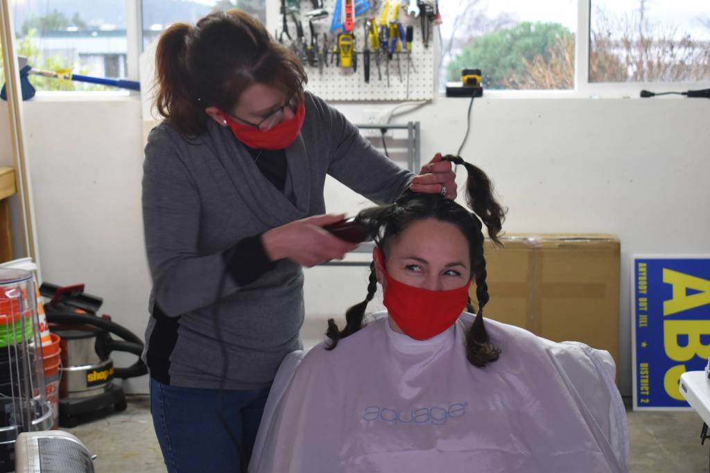 Naomie Welshans shaves Cheryl Lueders head in a show of support for Annie Cash. Photo by Emily Gilbert/Whidbey News-Times