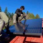 Adam Wundrow of Whidbey Sun and Wind installs a solar panel. Photo by Cary Peterson