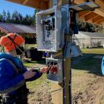 Golda Moore of Whidbey Sun and Wind adjusts wiring for the solar panels. Photo by Cary Peterson