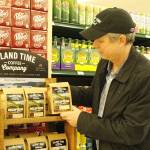 Photo by Kira Erickson/Whidbey News Group
Christopher Baldwin, owner of Island Time Coffee Company, arranges a display in Payless Foods.