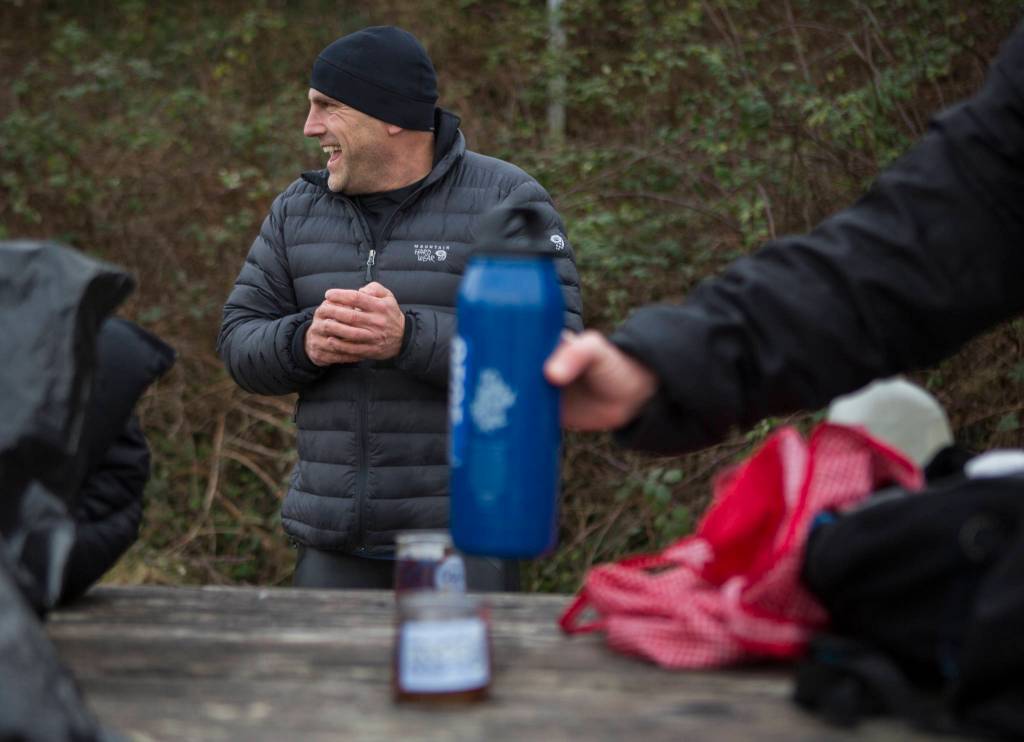 Joe Hempel laughs as passersby ask about what they are doing Jan. 29 while hot tea is passed around in Langley. (Olivia Vanni / The Herald)