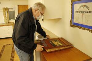 Deer Lagoon Grange Master Chuck Prochaska looks through a book of historic documents on the grange. (Photo by Kira Erickson/South Whidbey Record)