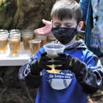 Photo by Bob OBrien
Third grader Colin Goodman carefully observes the silver salmon he has helped raise for the past three months. It was one of 227 salmon that was released Friday afternoon into Maxwelton Creek. By the time Goodman is in seventh grade, the salmon he released may return to the creek to spawn.