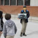 Photo by Kira Erickson/South Whidbey Record
Americorps Volunteer Elizabeth Bentz shows a photo of a gray whale to third grade students Alistaire Kirkconnell and Evan Del Faro.