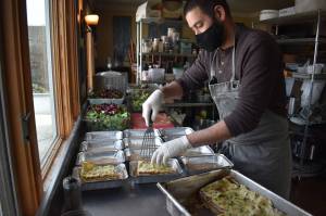 The Oystercatchers owner and chef, Tyler Hansen, prepares a dozen 3 Sisters beef bolognese lasagnas to go on the shelves at 3 Sisters Market. Photo by Emily Gilbert/Whidbey News-Times