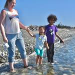 Four-year-old Tula Pierre-Louis and her brother, Iuri, play in the waves with mother Atty at West Beach in Deception Pass State Park. Its the beginning of peak season for Washingtons most popular state park. (Photo by Emily Gilbert/Whidbey News-Times)