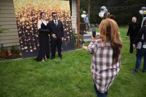 Synnove Svendsen and her boyfriend Landon Pohlman pose for a picture at a prom hosted in her familys backyard last Saturday. (Photos by Emily Gilbert/Whidbey News-Times)