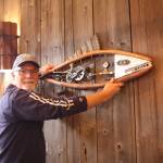 Artist Mark Wacker hangs a fish ornament he created for the taproom barn.