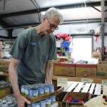 North Whidbey Help House deputy director Eric Mager stocks food in the warehouse. (Photo by Karina Andrew/Whidbey News-Times)