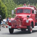 A local firefighter throws candy to kids watching the parade. (Photo by Karina Andrew/Whidbey News-Times)