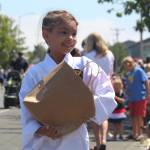 A young girl hands out candy to parade watchers. (Photo by Karina Andrew/Whidbey News-Times)