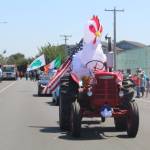 The promise of sunny weather and a welcoming crowd of old and young alike brought Oak Harbors own giant chicken to the celebration, here relying on a tractor to navigate the parade route. (Photo by Karina Andrew/Whidbey News-Times)
