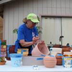 Lions Club member Marilyn Pulk prices pots to be sold at the garage sale this weekend. (Photo by Karina Andrew/Whidbey News-Times)