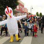 Karina Andrew/Whidbey News Group
Oak Harbor's famous chicken dances with the crowds at the Oak Harbor Music Festival Saturday. Ever the trendsetter, it appears a flock of fans have copied his signature pose while he struts about the town during the multi-day music festival.