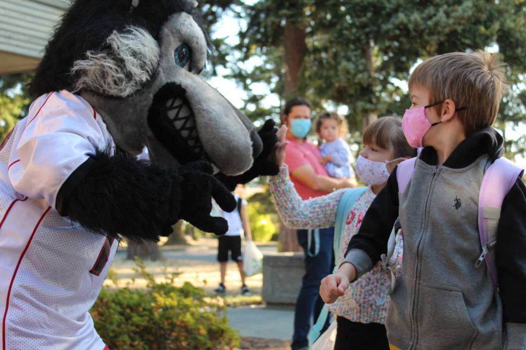 Photo by Karina Andrew/Whidbey News-Times
Students at Coupeville and Oak Harbor schools returned to class this week. Above, Matthew Richards, right, and Elizabeth Richards high five the wolf before going to find their classrooms at Coupeville Elementary.