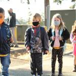 From left, Leo Hernandez-Gomez, Rex Burley, Adelaide Burley and Valerie Trevino wait in line to enter the school and find their new classrooms. (Photo by Karina Andrew/Whidbey News-Times)