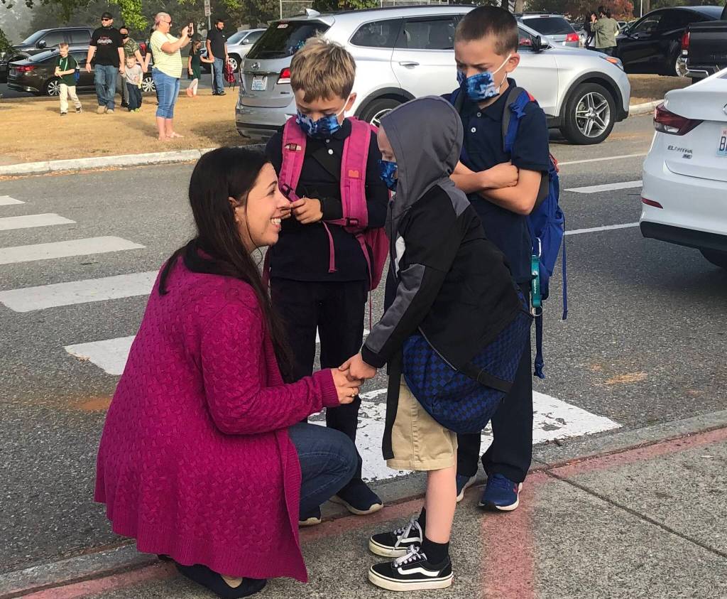 Photo by Emily Gilbert/Whidbey News-Times
ReKann Brannon cheers up here three sons, Hayes, who is going into fourth grade, Johnny, who is going into third grade, and Owen, who is going into first grade, before their first day of school at Oak Harbor Elementary on Sept. 9.