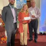 Pastor Greg Steible, left, and church stewardship chair Jim Rohrback present Mother Mentors Director Kate McVay with a check for $10,000 on Sept. 12. (Photo provided)