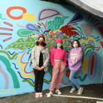 Photo by Karina Andrew/Whidbey News-Times
Oak Harbor High School junior Amelia Dawn Nguyen, left, artist Nikita Ares, center, and Oak Harbor junior Kaydence Murdock show off their freshly re-painted mural on Pioneer Way.