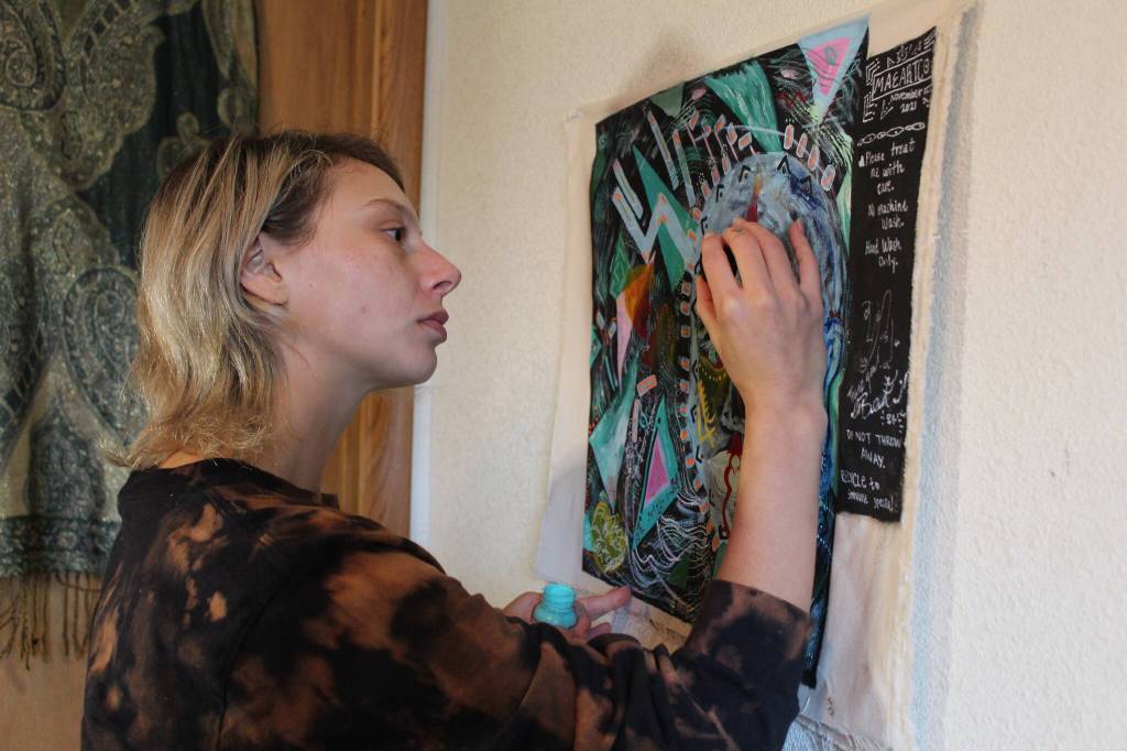 Photo by Karina Andrew/Whidbey News-Times
Nora Boehm adds the finishing touches to a commissioned textile painting to be sewn onto the back of a jacket. Boehm will be selling some of her art work at the All Hands Holiday Bazaar, put on by the Officers Spouses Club of Whidbey Island on Dec. 4 in Oak Harbor.