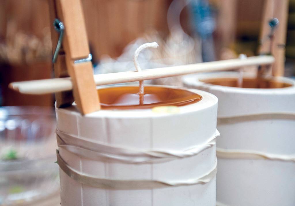 Freshly poured wax hardens in a candle mold. Lowry starts her process with 20-pound chunks of beeswax she buys from Northwest apiaries. (Olivia Vanni / The Herald)