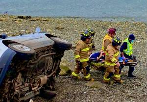 Photo provided
Firefighters carry a driver from the scene of a vehicle accident after the driver rolled his car near Penn Cove.