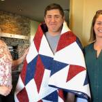 Photo by Harry Anderson
<em>Colleen Jones, left,and Tanya Gardner congratulate William Carroll on his new quilt.</em>