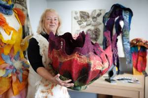 Fiber artist Janet King holds an enormous felt creation she refers to as a vessel. King is one of the participating artists on the Whidbey Art Trail this year. (Photo by David Welton)