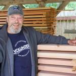 Wallgren with wooden planks he makes picnic tables out of. (Photo by Rachel Rosen/Whidbey News-Times)