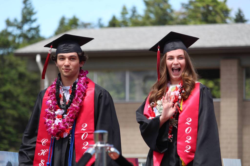 Photo by Karina Andrew/Whidbey News-Times
Eryn Wood, right, waves to the crowd as she walks in with fellow Coupeville graduate Hawthorne Wolfe.