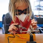 Solomon Hilliard, 13, solders some wires together. (Photo by David Welton)