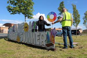 Leah and Aaron Meschke of Whidbey Yard Cards set up celebratory yard signs. (Photo by Karina Andrew/Whidbey News-Times)