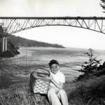 Dept. of Commerce and Economic Development
A boy with a picnic basket is photographed in front of Deception Pass Bridge in 1950.