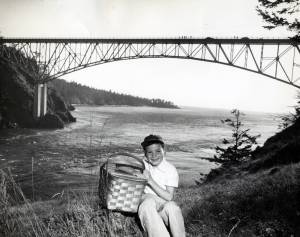 Dept. of Commerce and Economic Development
A boy with a picnic basket is photographed in front of Deception Pass Bridge in 1950.