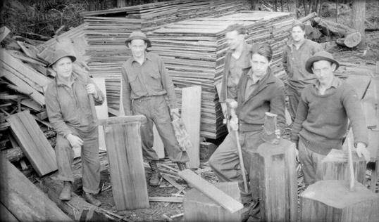 Above, a work crew chops wood in Deception Pass State Park. Below, Civilian Conservation Corps members gather near buildings under construction. (Washington State Archives photos)