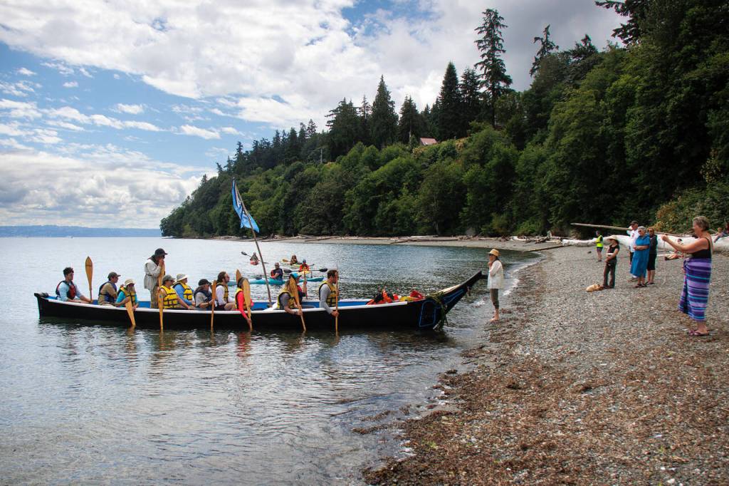 The Blue Heron Canoe Family is greeted on the shore at Sandy Point. (Photo by David Welton)