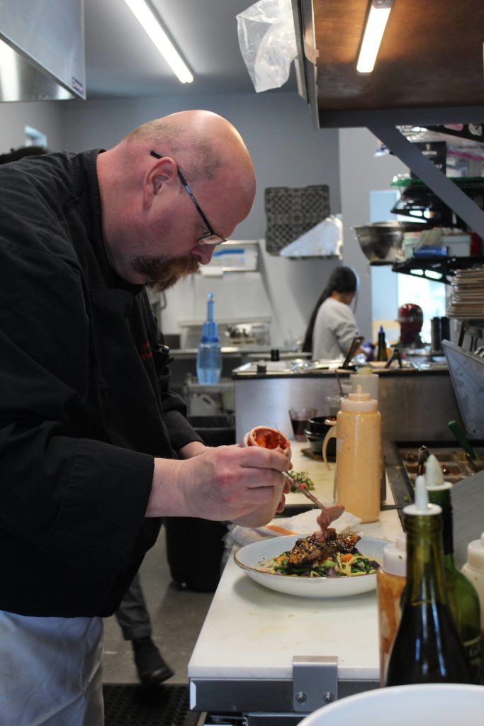 Gordon Stewart prepares a meal at Gordons Fusion July 8. (Photo by Karina Andrew/Whidbey News-Times)