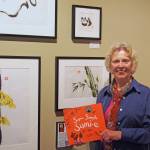 Yvonne Palka at the Whidbey Art Gallery holding her second book, an award-winning instruction book for children on how to do sumi-e painting. (Photo provided)