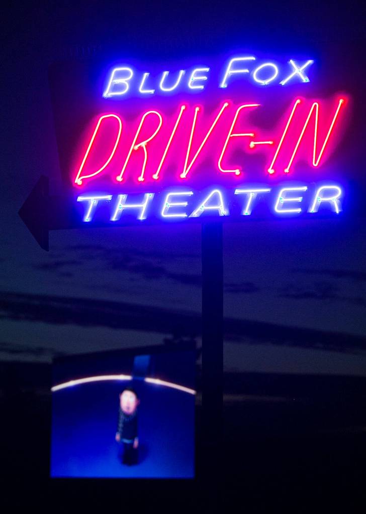 Minions: The Rise of Gru plays on the projector screen as the Blue Fox Drive-In Theater sign glows in the nighttime at the Oak Harbor outdoor movie theater. (Ryan Berry / The Herald)